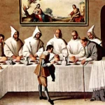 Monjes cartujos vestidos de blanco sentados a la mesa del refectorio
